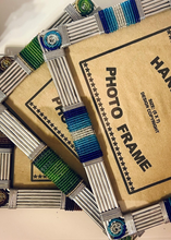 Load image into Gallery viewer, Two Picha Handmade Beaded Photo Frames by Her Best Foot Forward, crafted with wire, glass, and colorful beads by East African artisans, overlap diagonally. Labels read HANDMADE PHOTO FRAME, adding unique sustainable decor to any home.