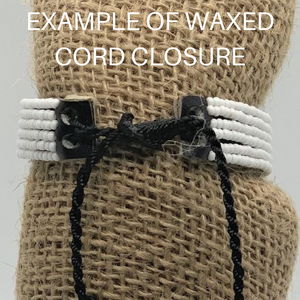 Close-up of a Share the LOVE Beaded Bracelet by Her Best Foot Forward—white beads, black waxed cord closure—handmade Maasai jewelry from East Africa. EXAMPLE OF WAXED CORD CLOSURE—a meaningful gift.