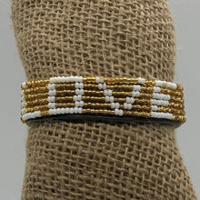 Load image into Gallery viewer, The Share the LOVE Beaded Bracelet by Her Best Foot Forward features white beads spelling LOVE among gold beads—a meaningful, handmade Maasai jewelry piece from East Africa, perfect as a unique and thoughtful gift.