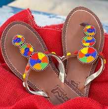 Load image into Gallery viewer, The Kelly Handmade Beaded Sandals by Her Best Foot Forward feature brown leather and vibrant Maasai beadwork in red, yellow, green, blue, and orange—an artisanal, ethical choice for summer style.