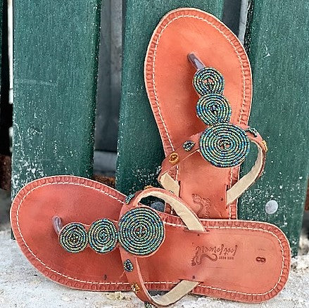 Pools of Green Handmade Beaded Sandals by Her Best Foot Forward feature Maasai beadwork in green, blue, and black—nature-inspired ethical footwear that adds an elegant touch to any look.