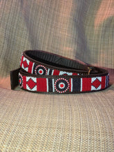 Load image into Gallery viewer, The Red Hot Dog Beaded Dog Collar by Her Best Foot Forward, a vibrant handmade Maasai ethical pet accessory from East Africa, is displayed on a beige textured fabric background.