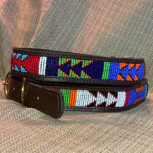 Load image into Gallery viewer, Two All the Way Up Beaded Dog Collars by Her Best Foot Forward, handmade by Maasai artisans in bold red, blue, green, orange, white, and black patterns, are displayed on beige fabric. Each is a unique ethical leather pet accessory from East Africa.