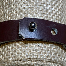 Load image into Gallery viewer, Close-up of the Safari Stripes Beaded Bracelet by Her Best Foot Forward, handmade Maasai jewelry from East Africa with alternating stripes, shown on textured beige woven fabric. Strap has a metallic stud fastener; one hole is slightly frayed.
