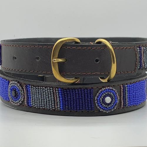 The Mia Beaded Dog Collar by Her Best Foot Forward features chic Maasai-inspired blue and silver beading on dark brown leather with a gold buckle, handcrafted ethically by women artisans in East Africa.
