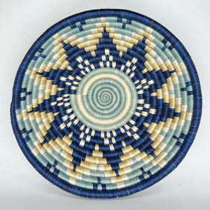 The Sunrise Handwoven Baskets by Her Best Foot Forward feature intricate, star-like blue, cream, and beige patterns. Crafted in East Africa from sweet grass, these round lids make stunning wall or table decor.