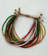 Load image into Gallery viewer, The SHANGA 14-Strand Beaded Bracelet by Her Best Foot Forward features red, green, gold, and white beads with yellow accents and a tan cord. This handmade Maasai jewelry is shown on a white background.