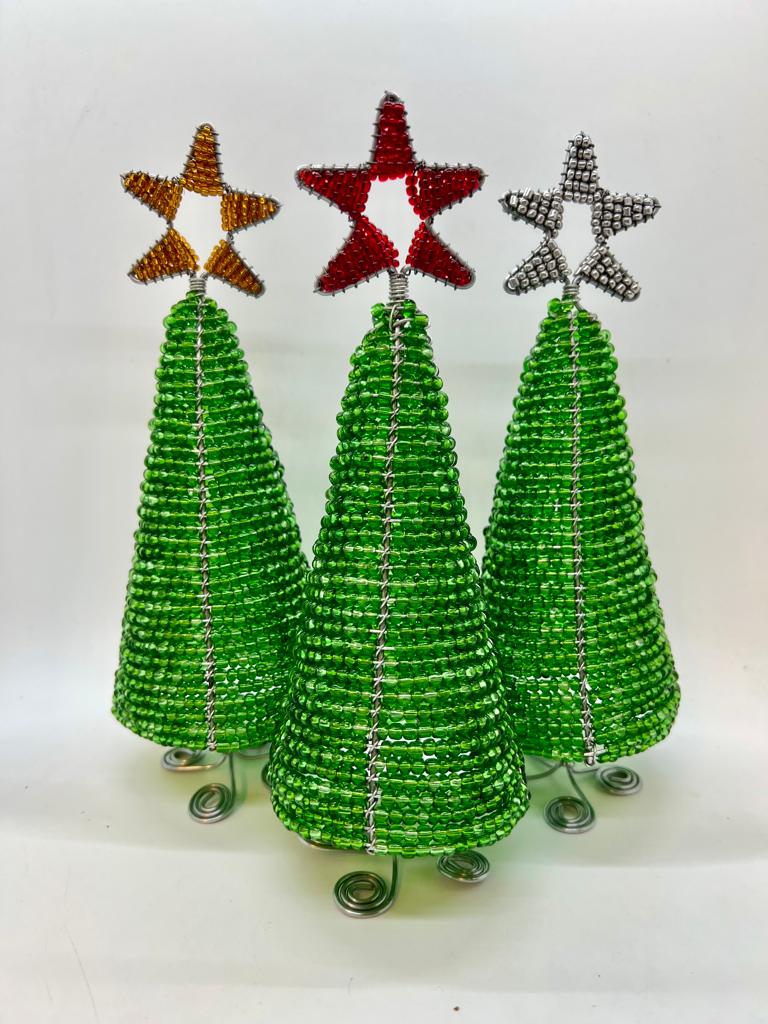 Three Hand-Beaded Christmas Trees by Her Best Foot Forward, crafted from reclaimed wire in Tanzania, each feature a spiral base and a gold, red, or silver star. These handmade holiday decorations are displayed against a plain white background.