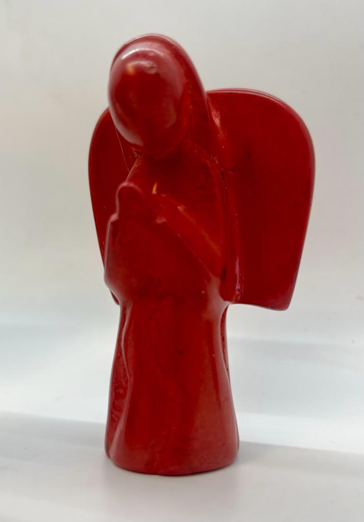 A hand-carved red soapstone angel from Her Best Foot Forward features folded arms and a featureless face, making it the perfect Christmas decor. This East African divine sculpture stands out against any plain white background.