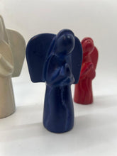 Load image into Gallery viewer, Three small, hand-carved soapstone angels from Her Best Foot Forward stand side by side in blue, white, and red. With simple, rounded features, these East African figures are a charming accent for Christmas decor.
