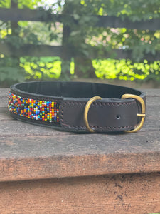 The Buddy Beaded Dog Collar by Her Best Foot Forward is a classic, handmade Maasai ethical pet accessory from East Africa—crafted with black leather, brass buckle, and colorful geometric beads for your furry friend.