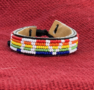 The Share the LOVE Beaded Bracelet by Her Best Foot Forward is a handmade Maasai jewelry piece from East Africa, featuring a geometric rainbow pattern on leather—a meaningful gift for someone special.