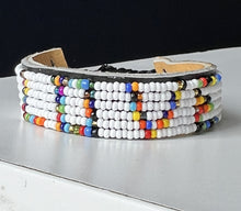Load image into Gallery viewer, The Share the LOVE Beaded Bracelet by Her Best Foot Forward is handmade Maasai jewelry from East Africa, featuring colorful beads spelling YES on white—a meaningful gift that looks stunning displayed on a light surface.