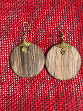 Load image into Gallery viewer, Rosemiti Hand-Carved Rosewood Earrings by Her Best Foot Forward feature brass accents and a statement design inspired by East Africa, displayed against a textured red background.