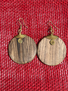 Rosemiti Hand-Carved Rosewood Earrings by Her Best Foot Forward feature brass accents and a statement design inspired by East Africa, displayed against a textured red background.