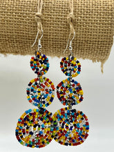 Load image into Gallery viewer, The Kiungo Conjoined Circle Earrings by Her Best Foot Forward are handmade Maasai statement jewelry from East Africa, featuring small, colorful beads in three linked circles, displayed against a textured burlap background.