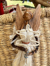 Load image into Gallery viewer, The Angels From On High Handcrafted Fiber Christmas Ornament by Her Best Foot Forward features a woven straw angel with leaf-like wings and braided arms, attached to a wicker basket, crafted by Tanzanian women artisans.