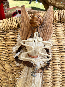 The Angels From On High Handcrafted Fiber Christmas Ornament by Her Best Foot Forward features a woven straw angel with leaf-like wings and braided arms, attached to a wicker basket, crafted by Tanzanian women artisans.