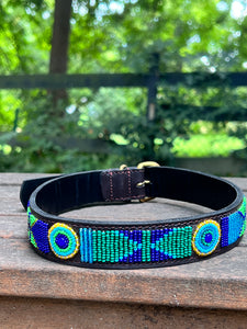 The Proud as a Peacock Beaded Dog Collar by Her Best Foot Forward features vibrant Maasai beadwork in blue, green, yellow, and turquoise geometric patterns—an ethical handmade pet accessory from East Africa.