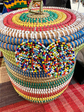 Load image into Gallery viewer, Her Best Foot Forward’s Duara Circular Beaded Earrings—handmade Maasai statement jewelry from East Africa—are displayed on a vibrant woven basket, highlighting their colorful circular patterns atop a multicolored mat.